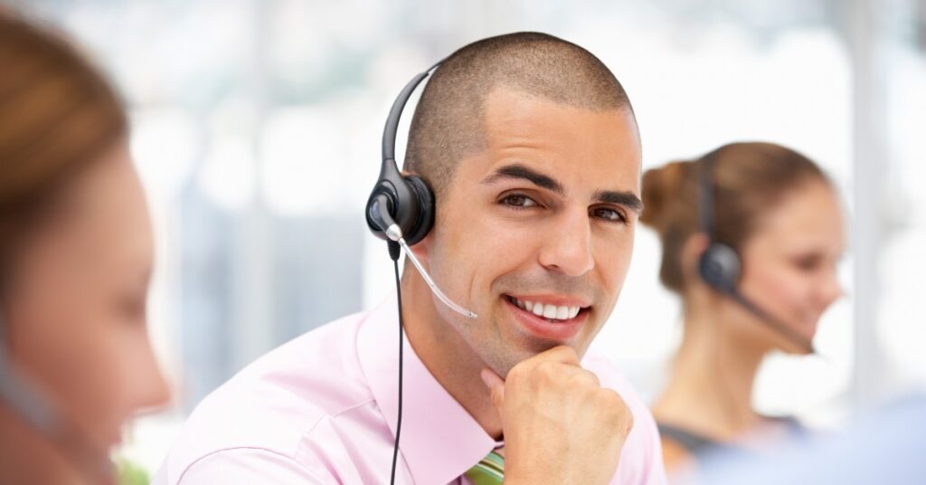 man wearing headset smiling at camera